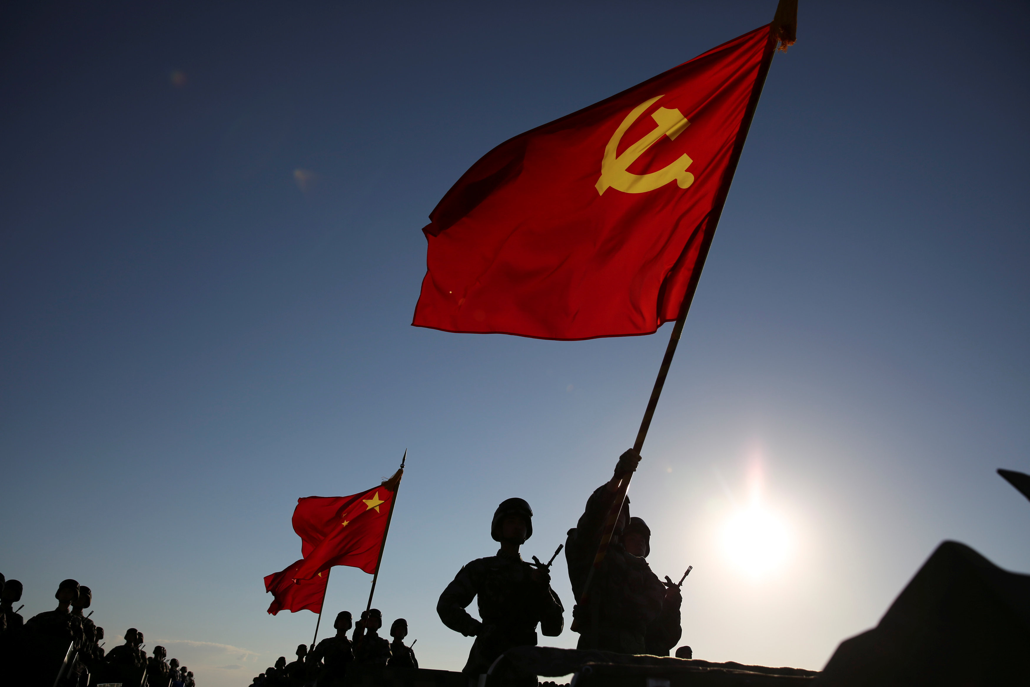 <p>Военнослужащие китайской армии несут национальные флаги страны на праздновании 90-летия&nbsp;основания НОАК. Фото: &copy; REUTERS/Stringer</p>