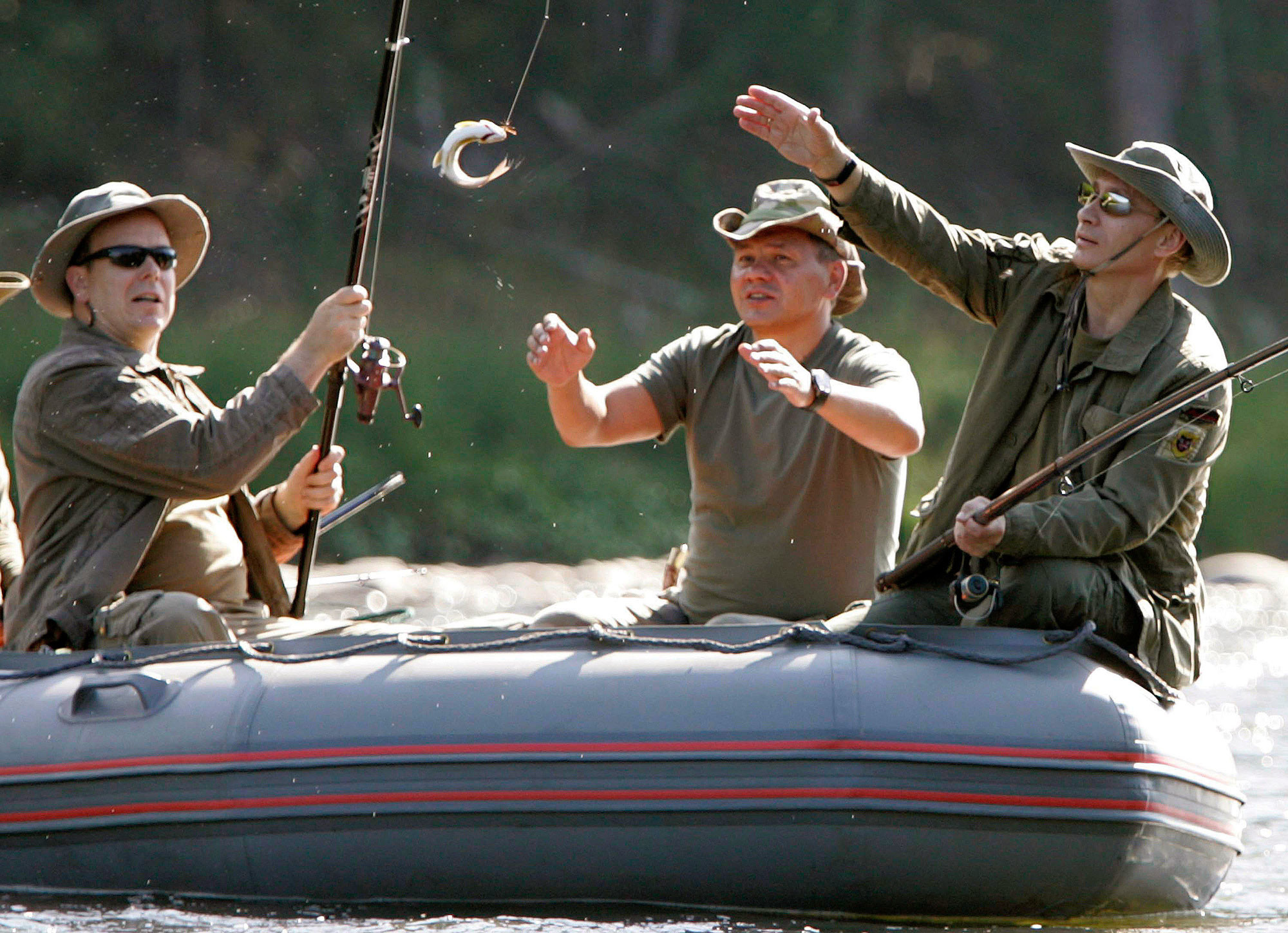 Президент России Владимир Путин, принц Альбер II и министр обороны РФ Сергей Шойгу ловят рыбу на реке Енисей в Сибири 13 августа 2007 года. Фото: © REUTERS/RIA Novosti/KREMLIN (RUSSIA)