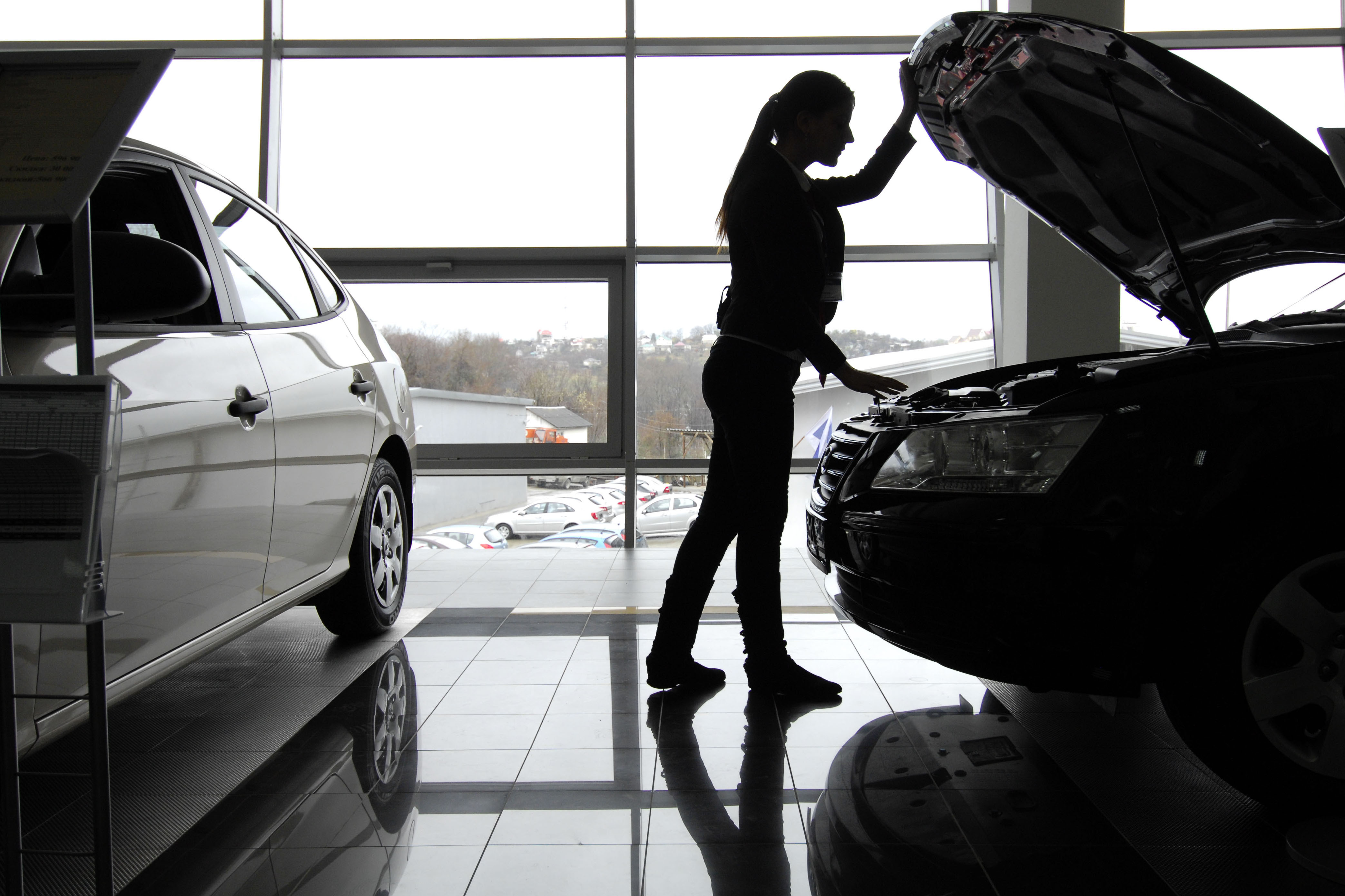 Посетительница осматривает автомобиль в автосалоне. Фото: &copy; РИА Новости/Михаил Мордасов