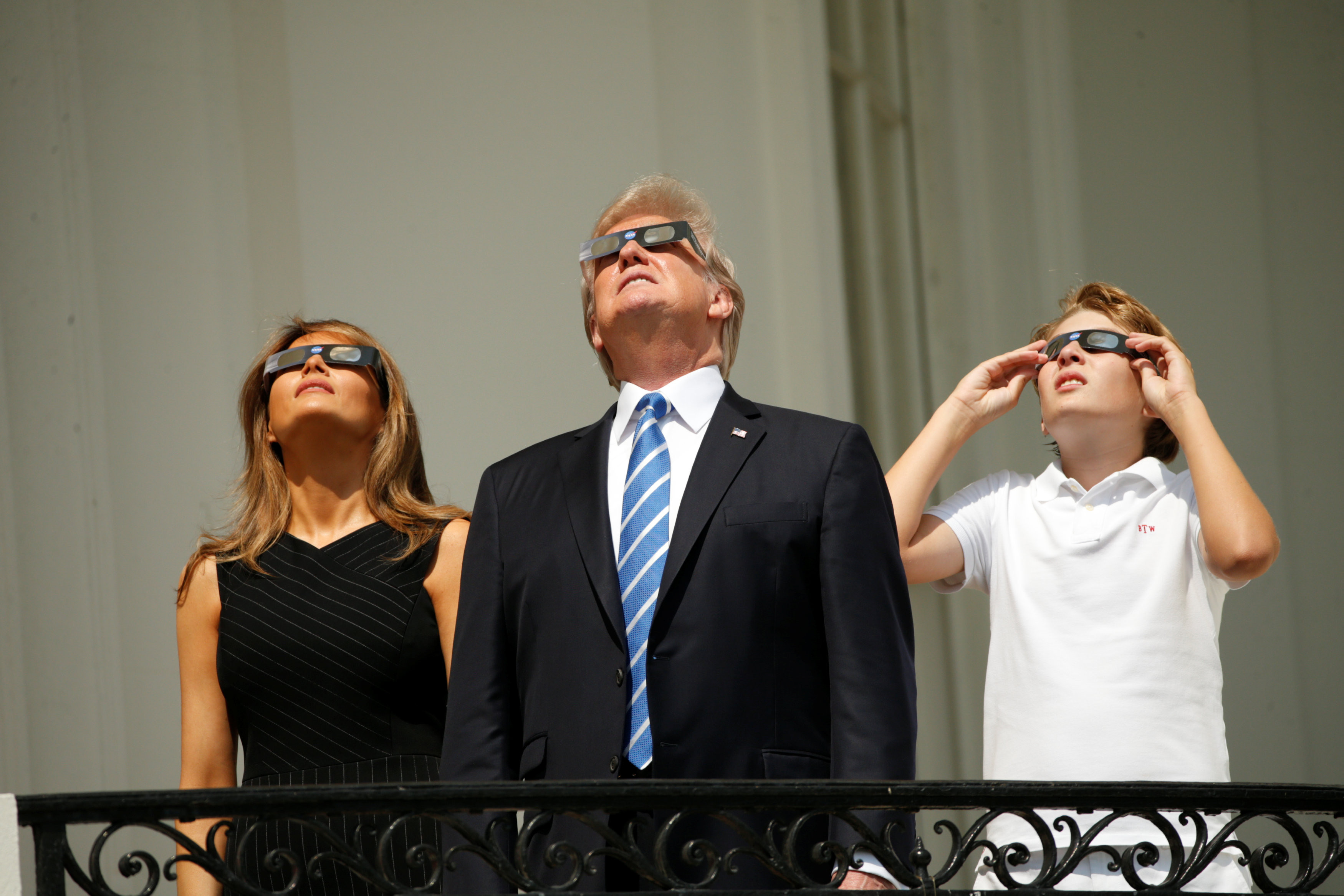 Дональд, Меланья и Бэррон Трамп наблюдают за солнечным затмением. Фото: &copy;&nbsp;REUTERS/Kevin Lamarque