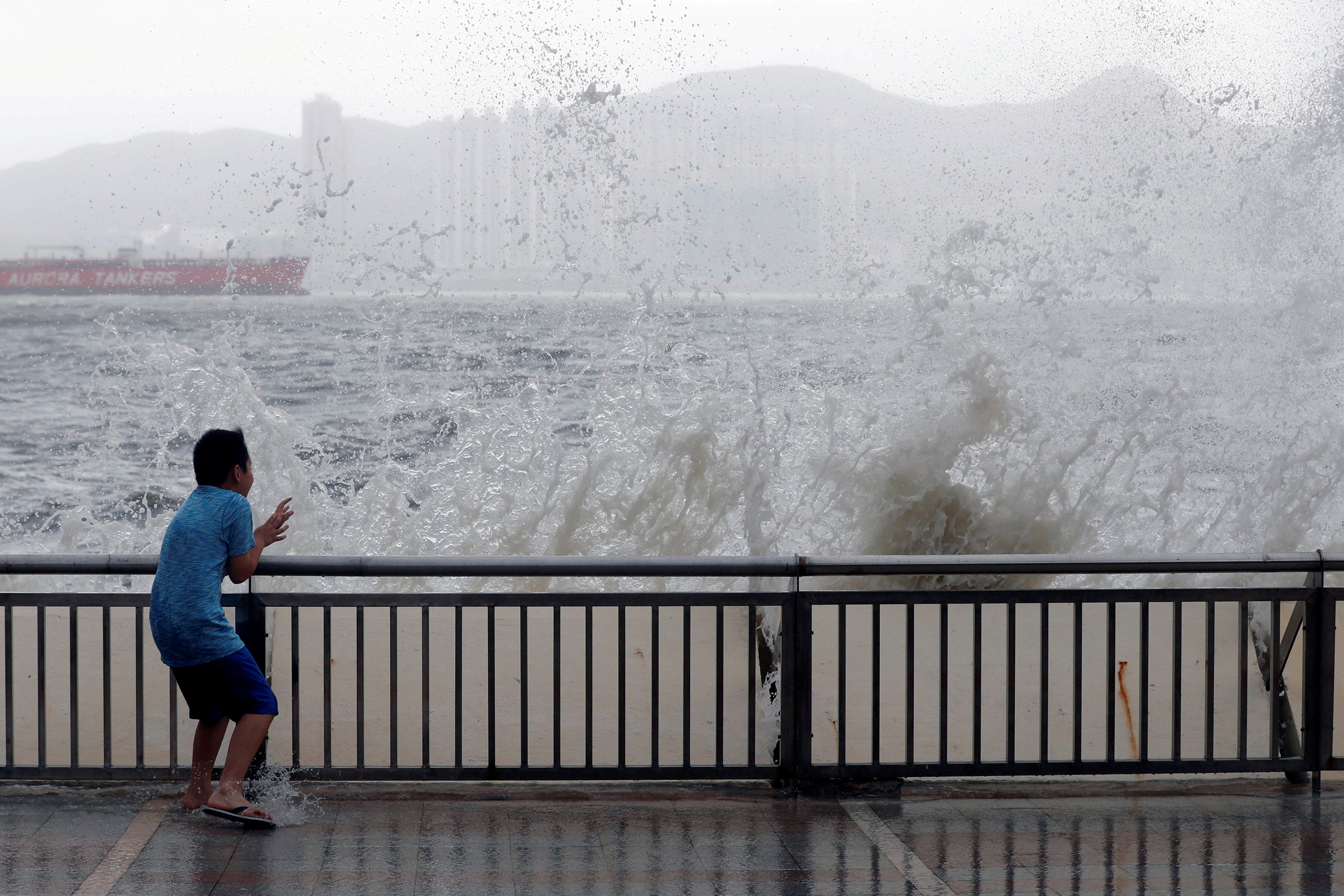 Мальчик стоит у моря во время тайфуна "Хато" в Гонконге. Фото: &copy; REUTERS/Tyrone Siu