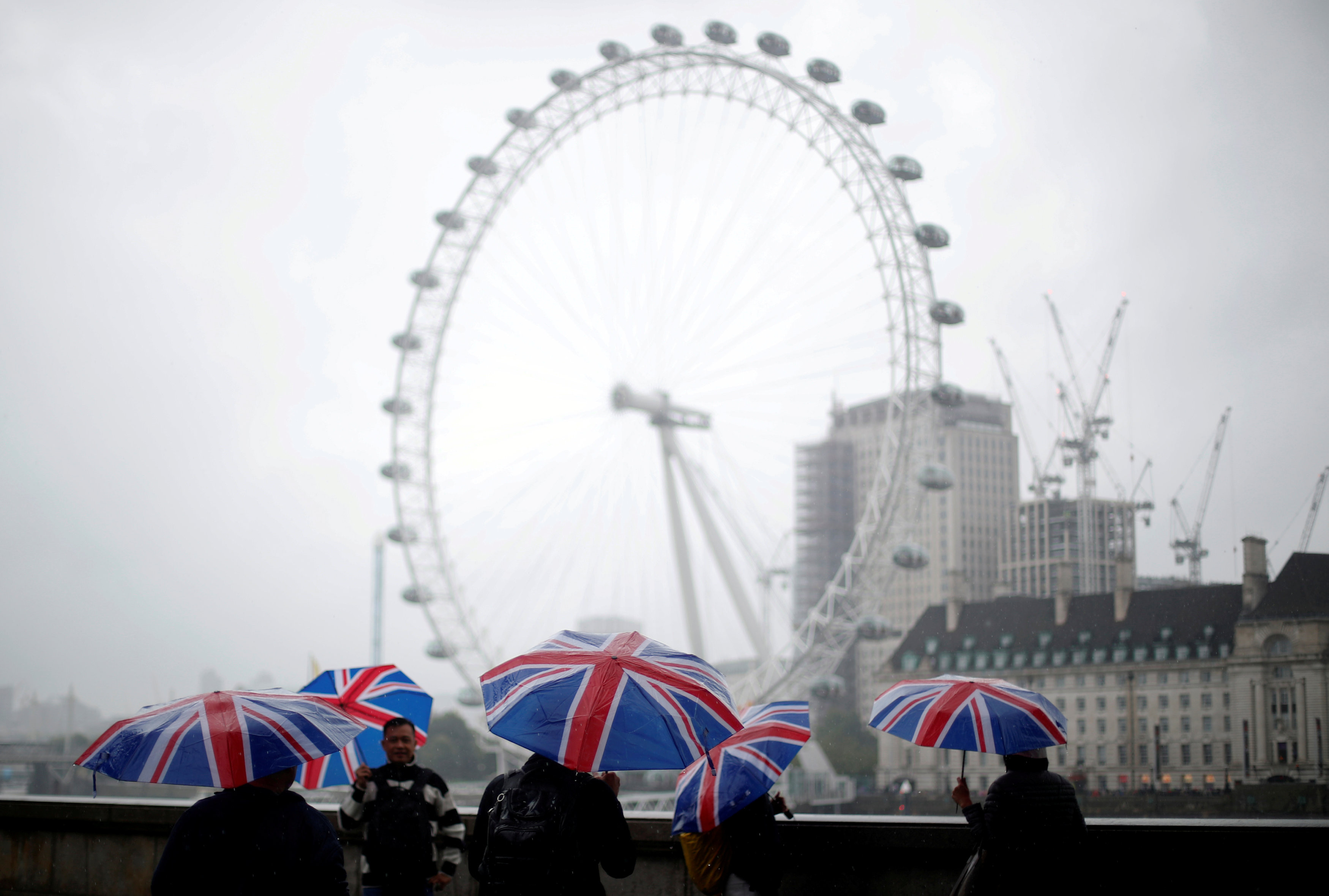 Туристы фотографируются на фоне колеса обозрения в Лондоне. Фото: &copy; REUTERS/Hannah McKay