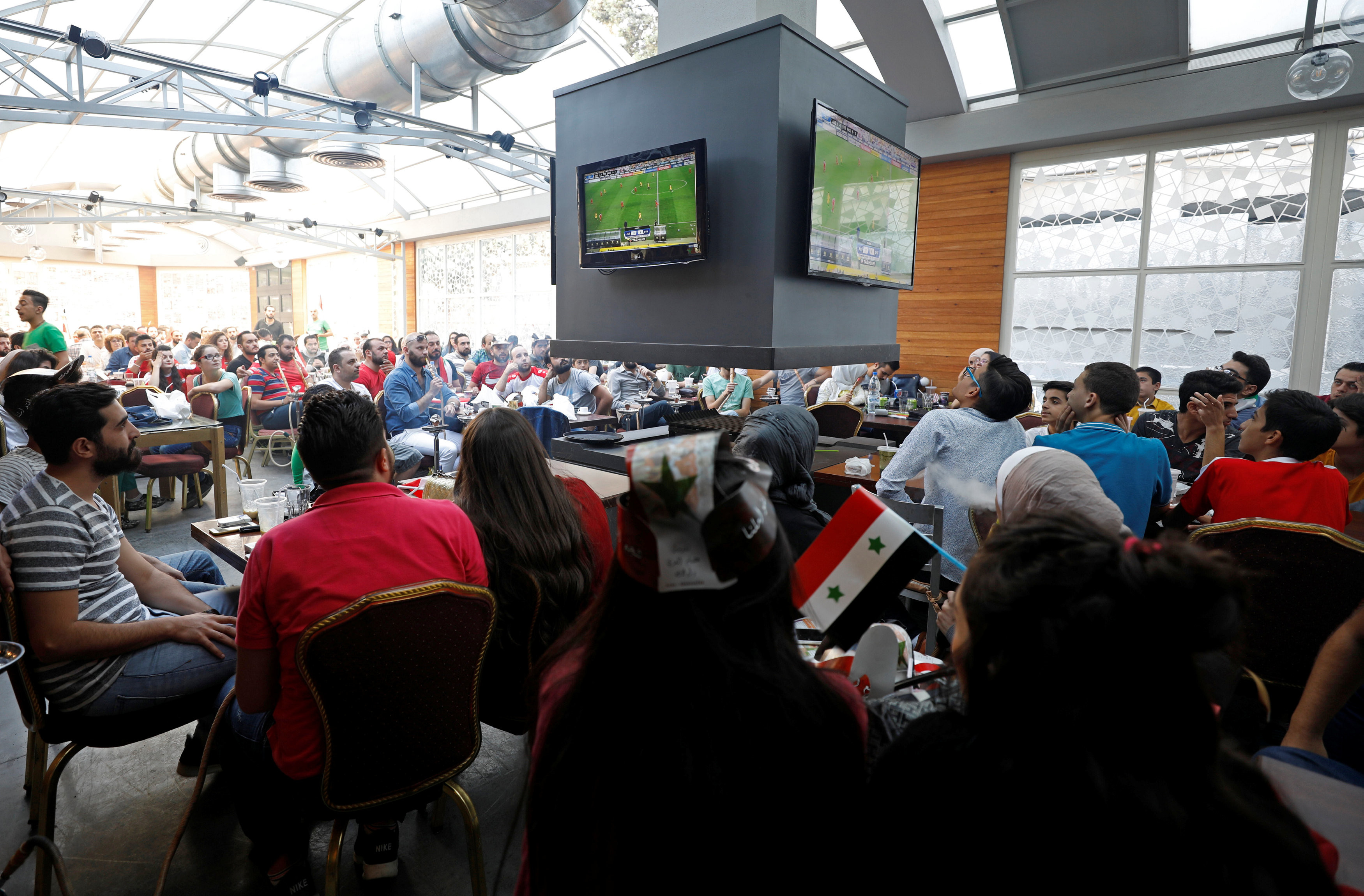 Люди смотрят матч Австралия — Сирия в баре в Дамаске. Фото: © Reuters/Omar Sanadiki