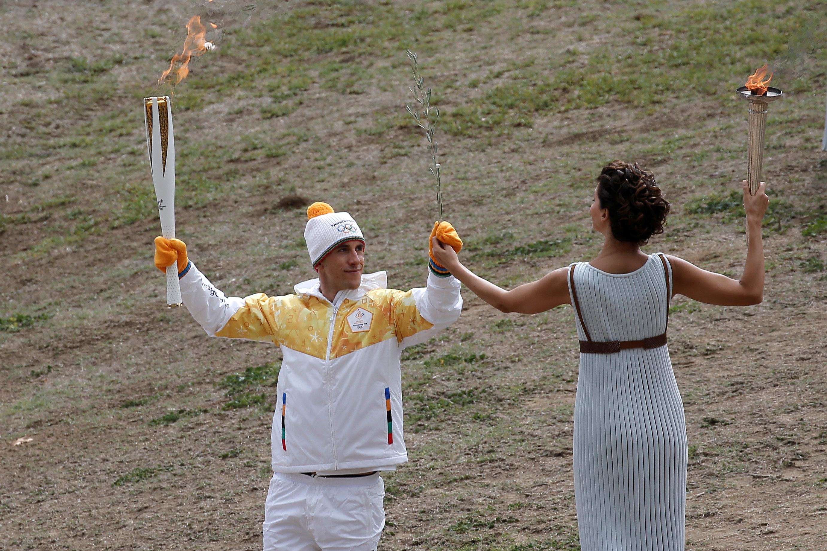 Факел современные игры зажигается. Зажжение олимпийского огня в Греции. Олимпийский огонь на горе Олимп. Олимпийский факел Греция.