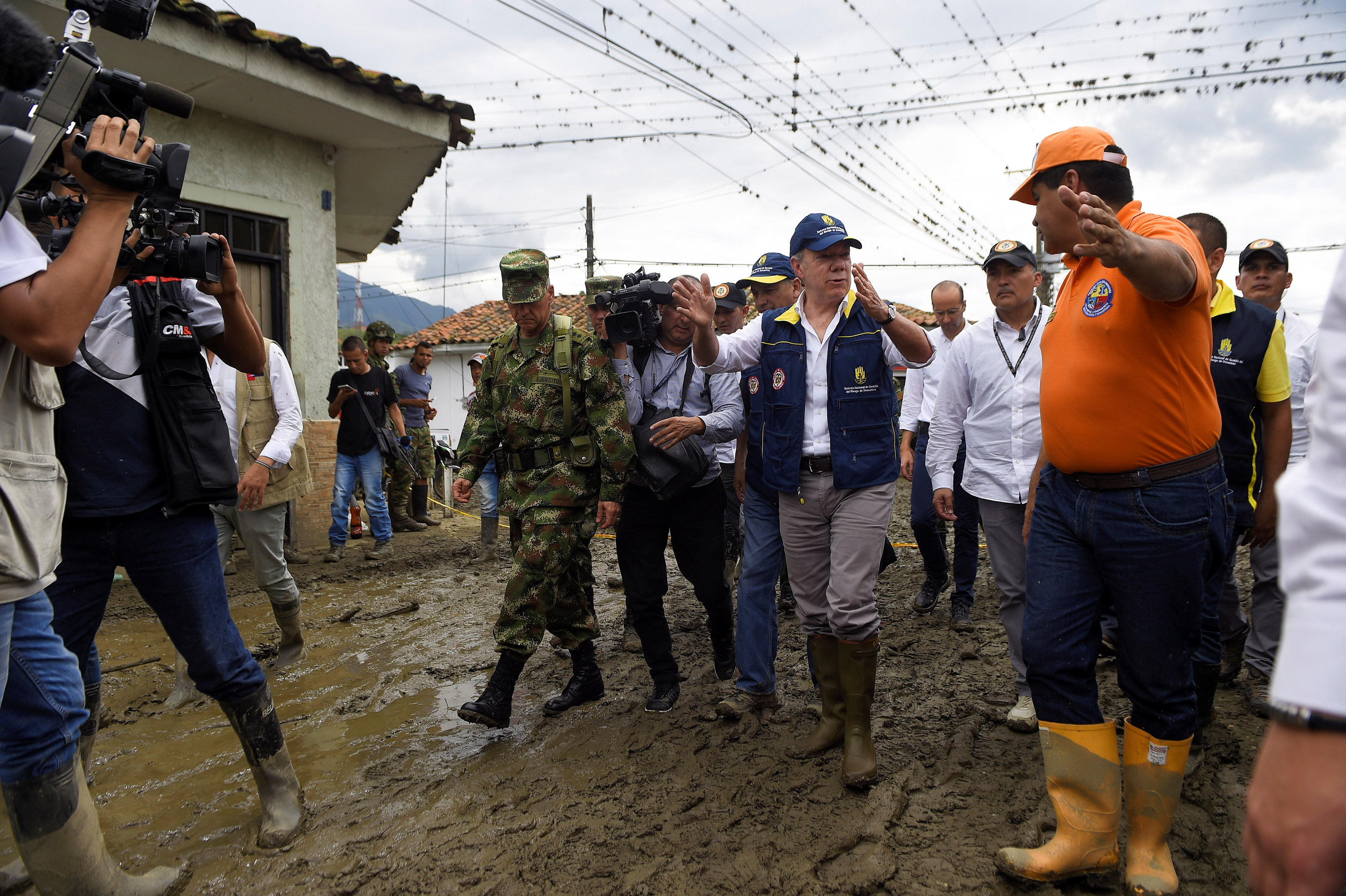 Президент Колумбии&nbsp;Хуан Мануэль Сантос идет по разрушенной оползнем улице. Фото: &copy;&nbsp;Presidency/Handout via REUTERS