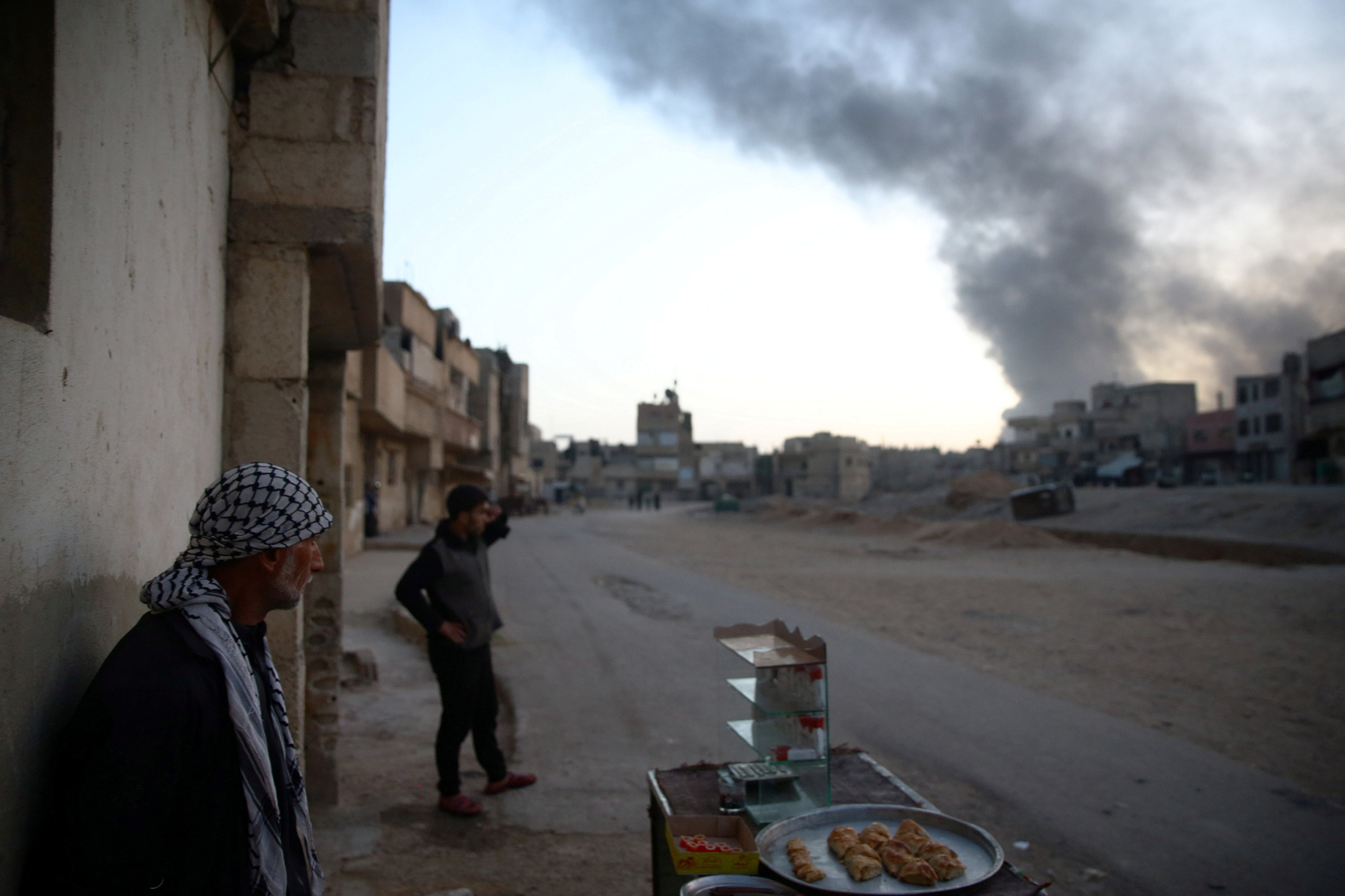 Жители Дамаска наблюдают за столбом дыма, поднимающимся над Гутой. Фото: &copy;&nbsp;REUTERS/Bassam Khabieh
