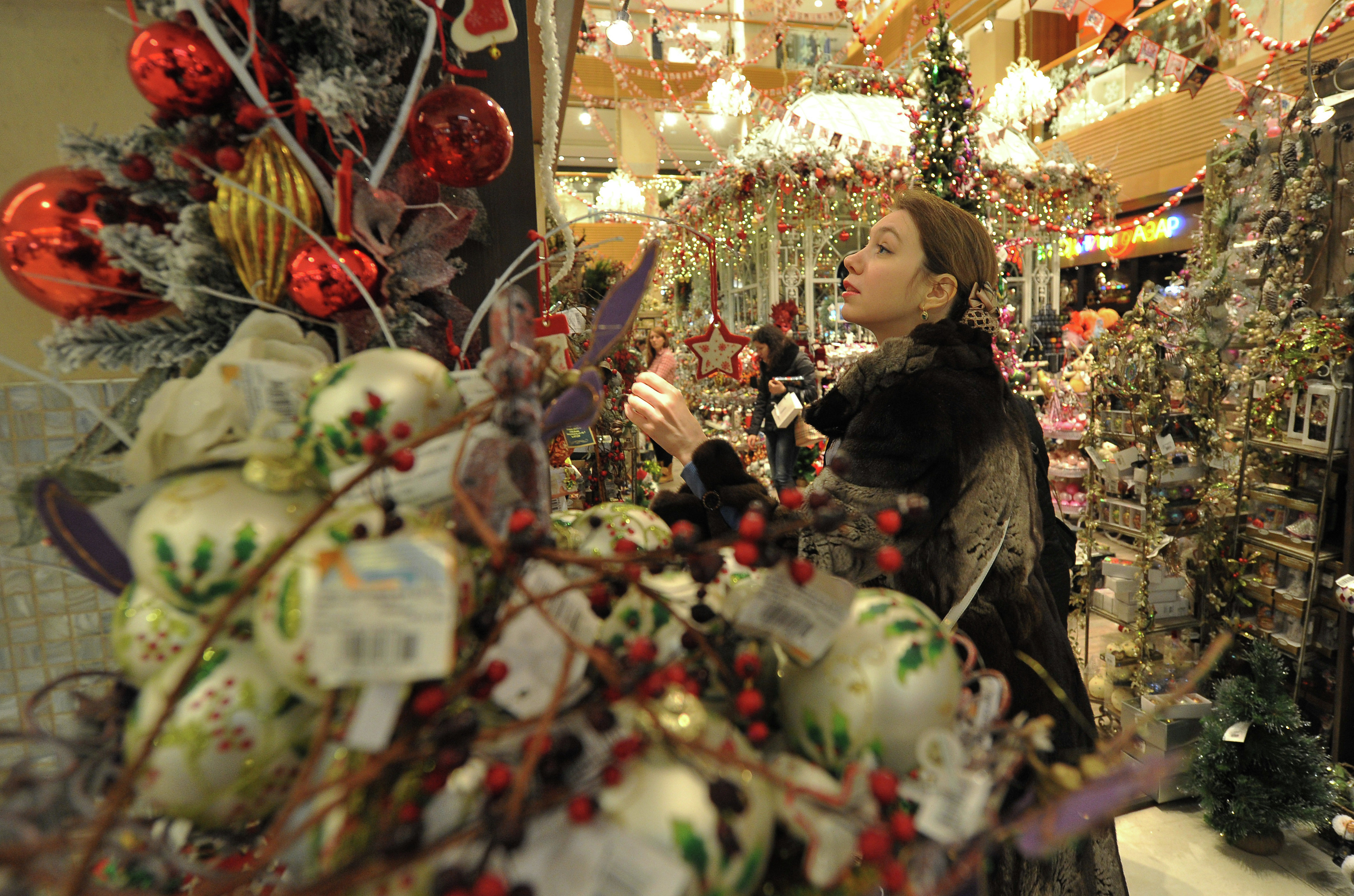 Покупательница выбирает товары на новогоднем базаре в ЦУМе. Фото: &copy;РИА Новости/Сергей Кузнецов&nbsp;