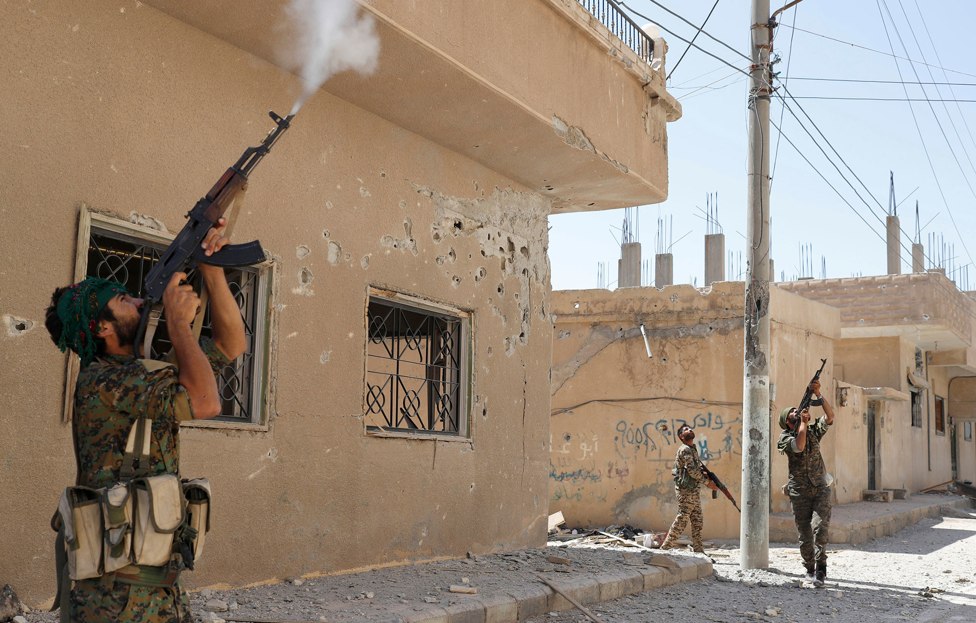 Курдские борцы стреляют по дронам противника из огнестрельного оружия в Ракке, Сирия. Фото: © REUTERS/Goran Tomasevic