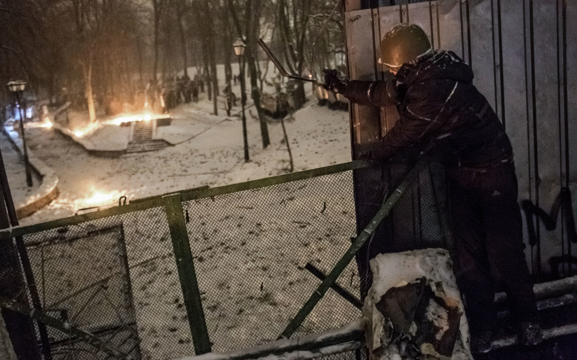Участник акции протеста стреляет в полицейских из пневматического пистолета на улице Грушевского в Киеве. Фото: ©РИА Новости / Андрей Стенин