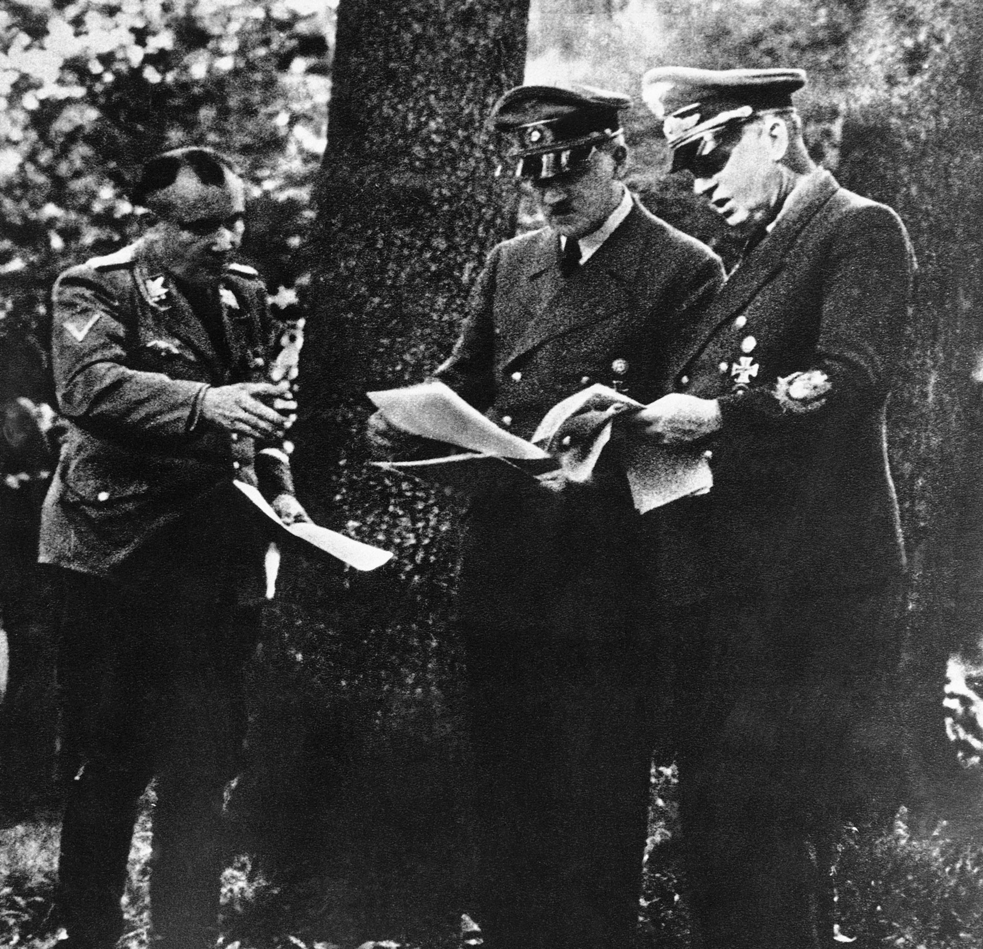 Во время открытой конференции министр иностранных дел Иоахим фон Риббентроп (справа) читает с канцлером Германии Адольфом Гитлером, госсекретарь Гитлера Мартин Борман (слева). Фото: © AP Photo