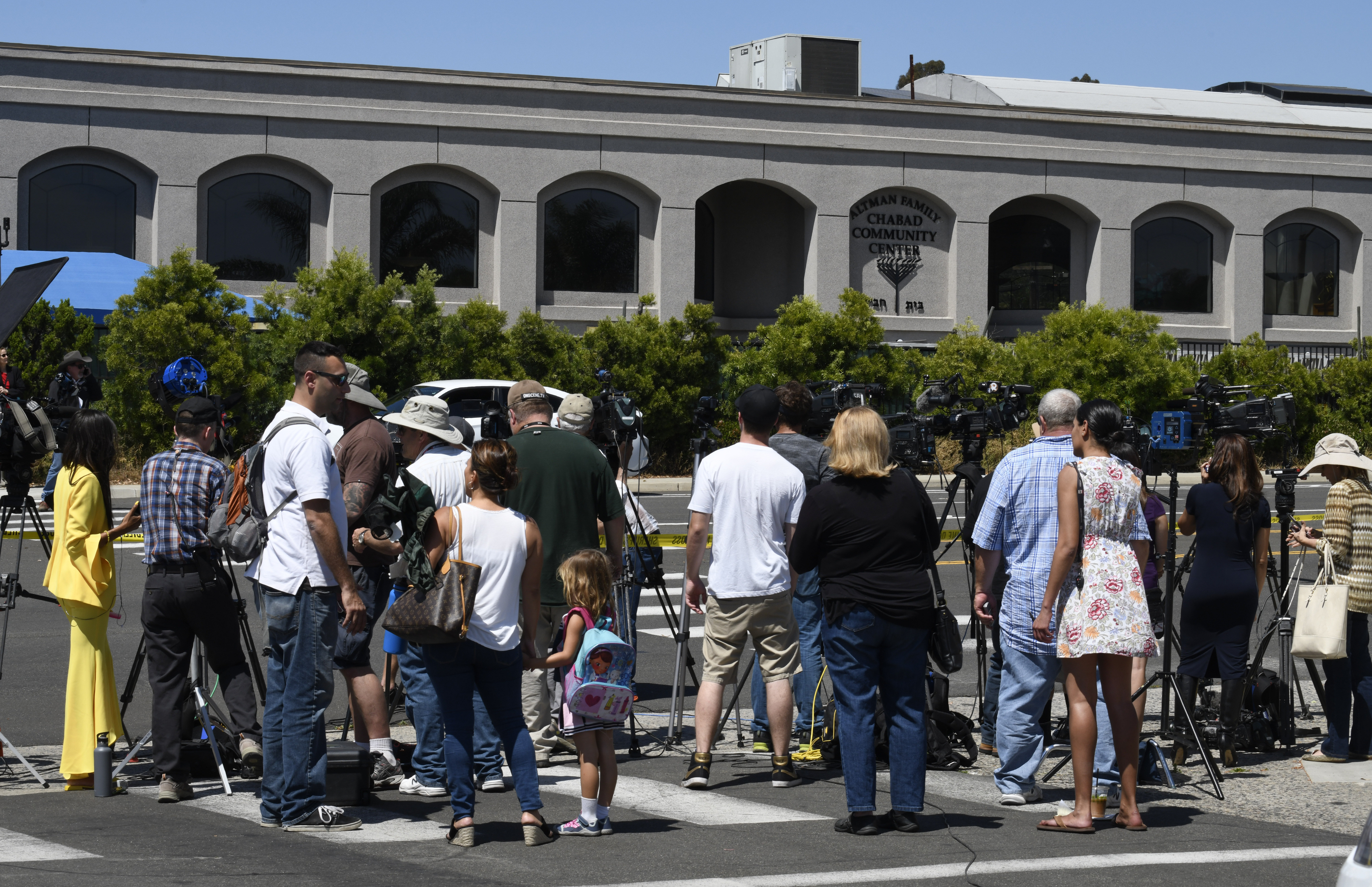 Местные жители и журналисты возле синагоги в Калифорнии, где произошла стрельба. Фото: © AP Photo/Denis Poroy
