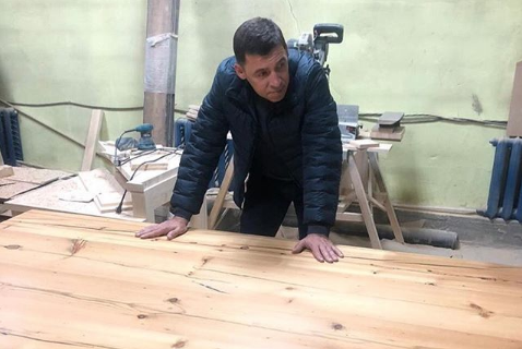 Губернатор Свердловской области Евгений Куйвашев и проданный на аукционе стол. Фото © Instagram/evgenykuyvashev
