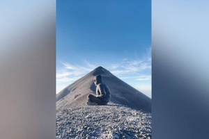 Парень мирно медитировал на горе, пока позади него не начал извергаться вулкан — видео