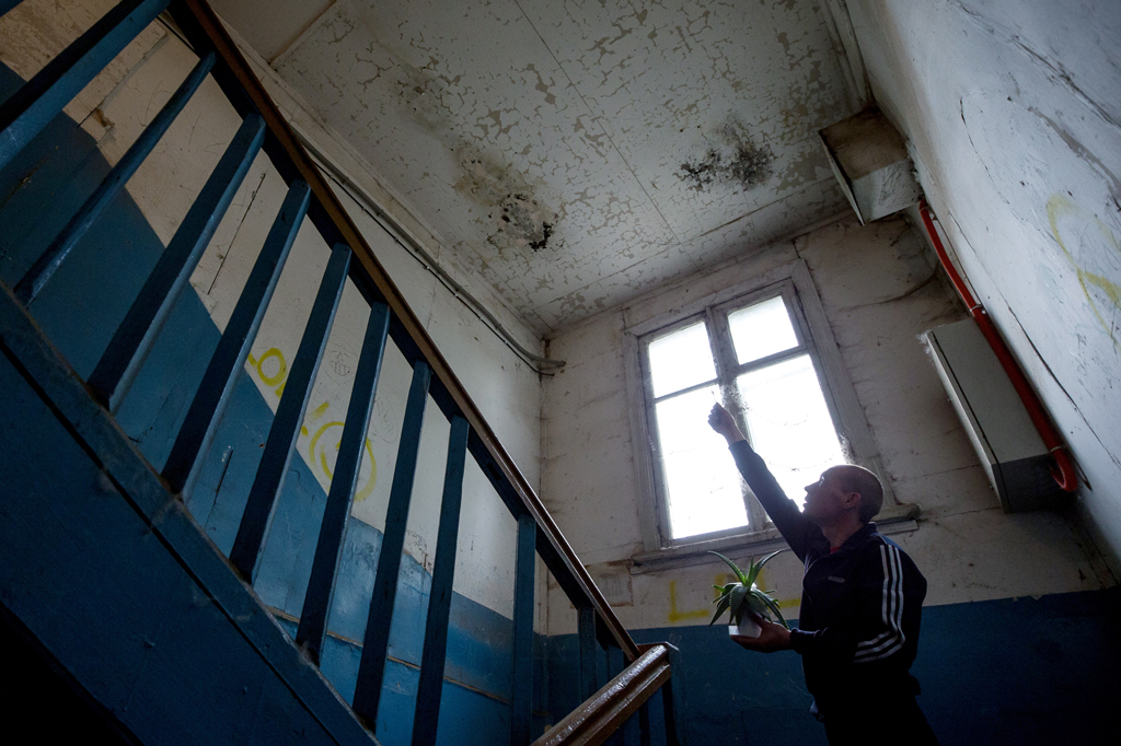 Мужчина в подъезде ветхого жилого дома. Фото © ТАСС / Егор Алеев