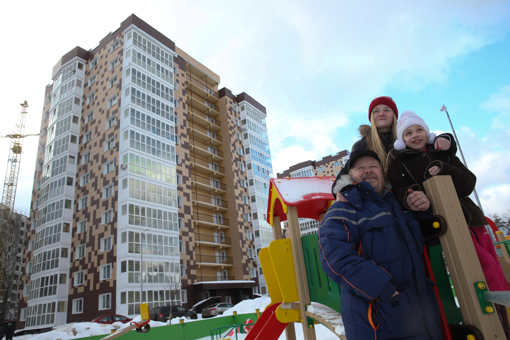 Многодетный отец Михаил Алешин и его дочери Анастасия и Дарья у своей новой квартиры. Фото © ТАСС / Вячеслав Прокофьев