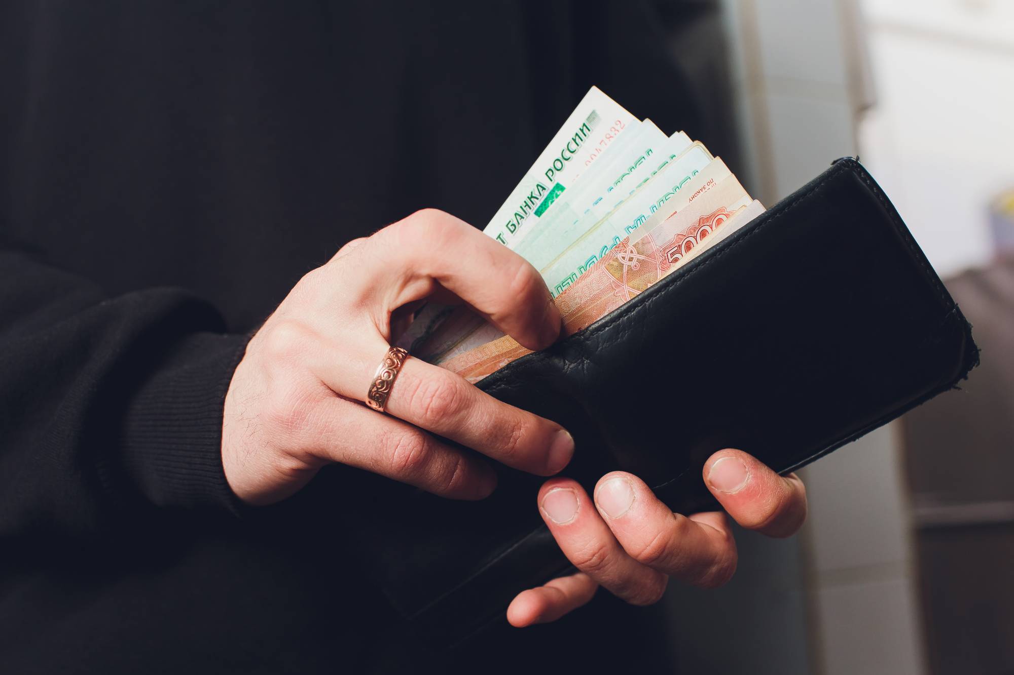 Менял выплаты. Держит много денег рубли. Man with Russian ruble. Russian rubles in the Wallet.