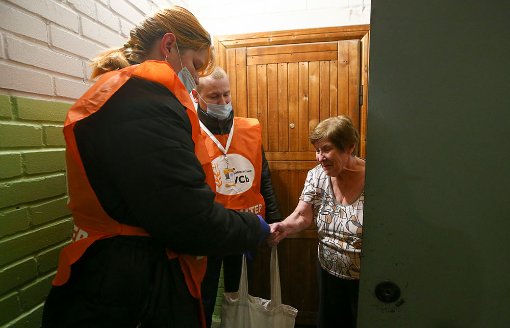 Волонтёры регионального штаба акции #МыВместе доставляют продукты пожилой женщине в период пандемии коронавируса. Фото © ТАСС / Пётр Ковалёв