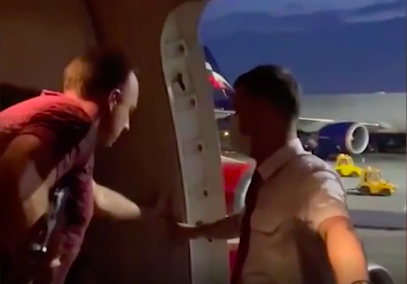 Открыл дверь в самолете. Пилотаотрывает дверь самолета. Вцепившись в дверь в самолете. Пассажир открывающий дверь.