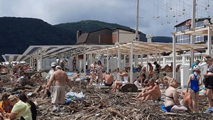 Отдыхающие на Кубани устроились загорать на пляже среди мусора и обломков 