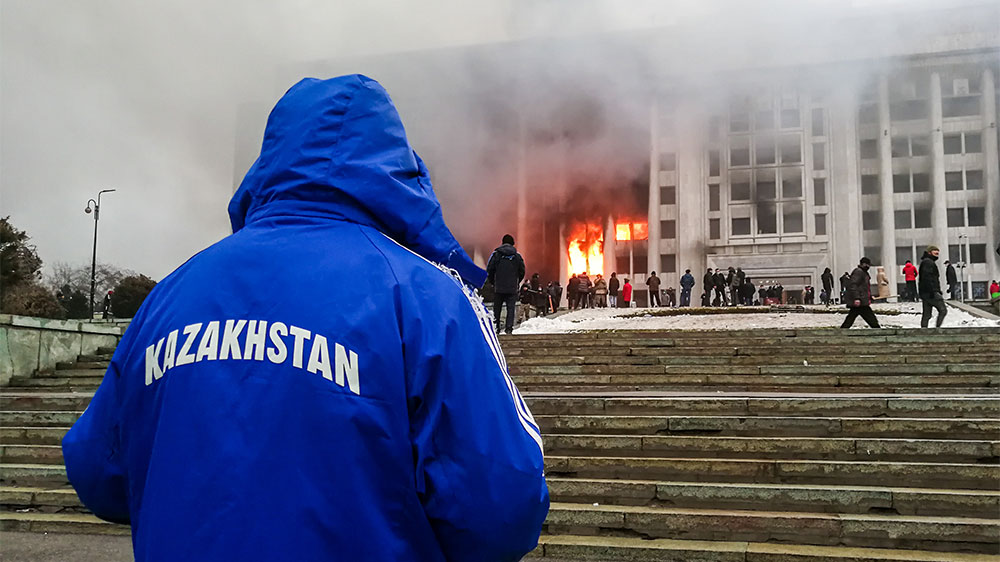 Протестующие возле горящего здания мэрии (акимат). Фото © ТАСС / Ерлан Джумаев