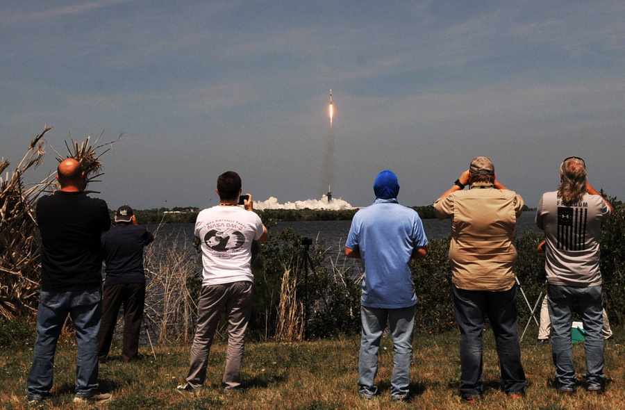 Люди наблюдают, как стартует ракета SpaceX Falcon 9. Фото © Getty Images / Paul Hennessy / SOPA Images / LightRocket