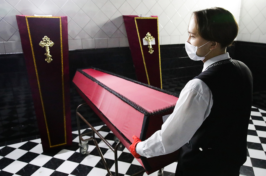 <p>Сотрудник Новосибирского крематория доставляет гроб в холодильное отделение. Фото © ТАСС / Кирилл Кухмарь</p>
