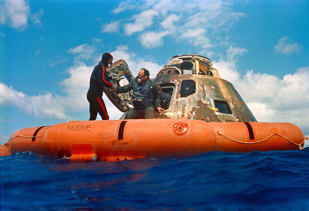 Морской водолаз помогает Эду Митчеллу спуститься на спасательный плот. Фото © Public Domain