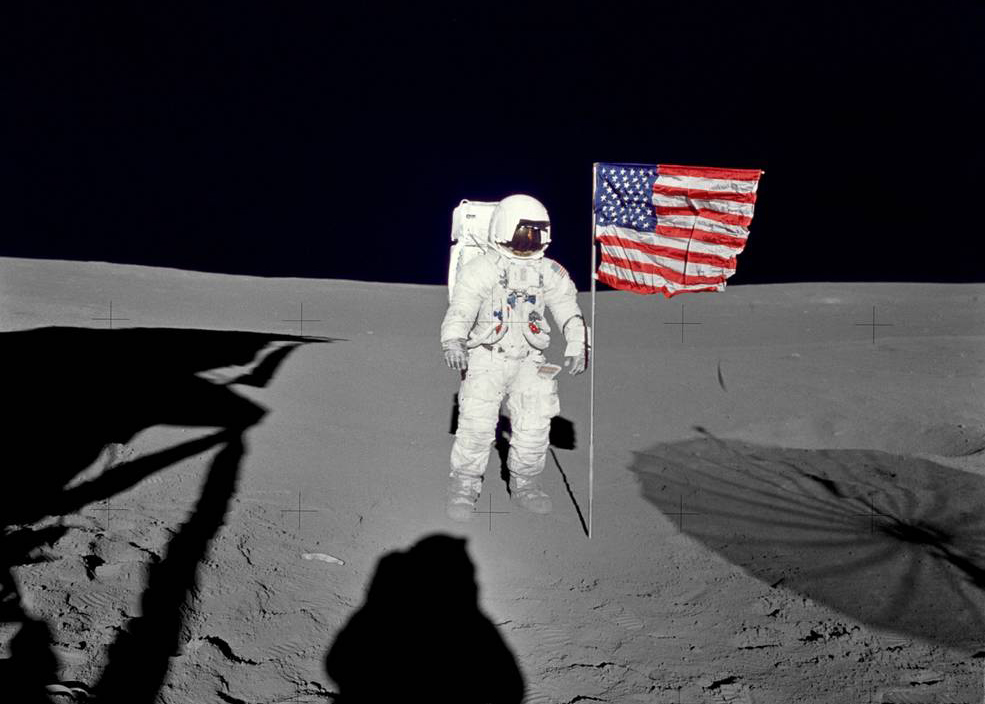 Астронавт Эдгар Митчелл, пилот лунного модуля "Аполлона-14", стоит у развевающегося флага США на поверхности Луны в первые моменты первого выхода миссии в открытый космос. Фото © NASA