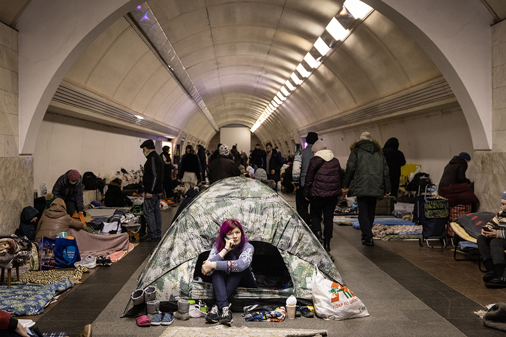 Женщина сидит в палатке на станции метро 