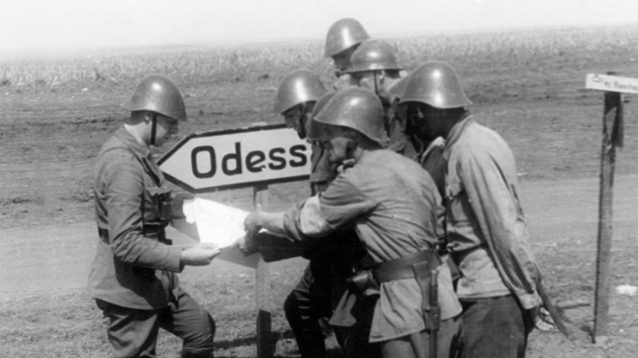 <p>Румынские солдаты изучают карту рядом с дорожным знаком, указывающим путь на Одессу. Август 1941 год. Фото © Getty Images / Mondadori</p>