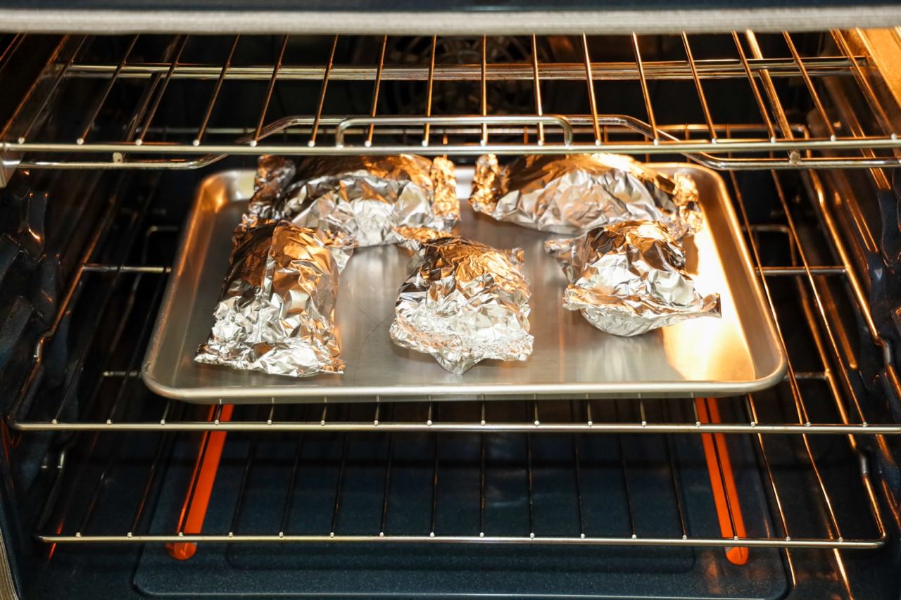 Половинки картофеля, замотанные фольгой, можно запечь в духовке, на углях или решётке. Фото © Shutterstock