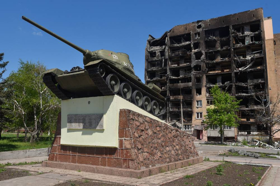 Мариуполь. Танк Т-34 на постаменте на фоне разрушенного дома. Фото © ТАСС / Николай Тришин