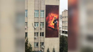 На фоне огненного знака Z: Баннер с украинской бабушкой украсил фасад главка МВД в Красноярске