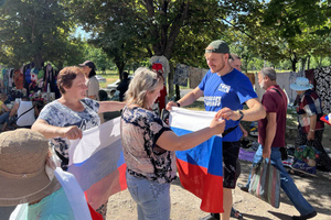 МГЕР и "Волонтёрская рота" раздали жителям Мариуполя тысячи флагов ко Дню России