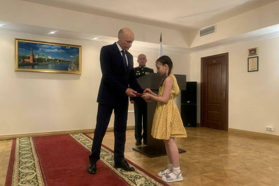 Марат Кулахметов передаёт награду дочери погибшего военнослужащего. Обложка © Пресс-служба посольства РФ в Южной Осетии