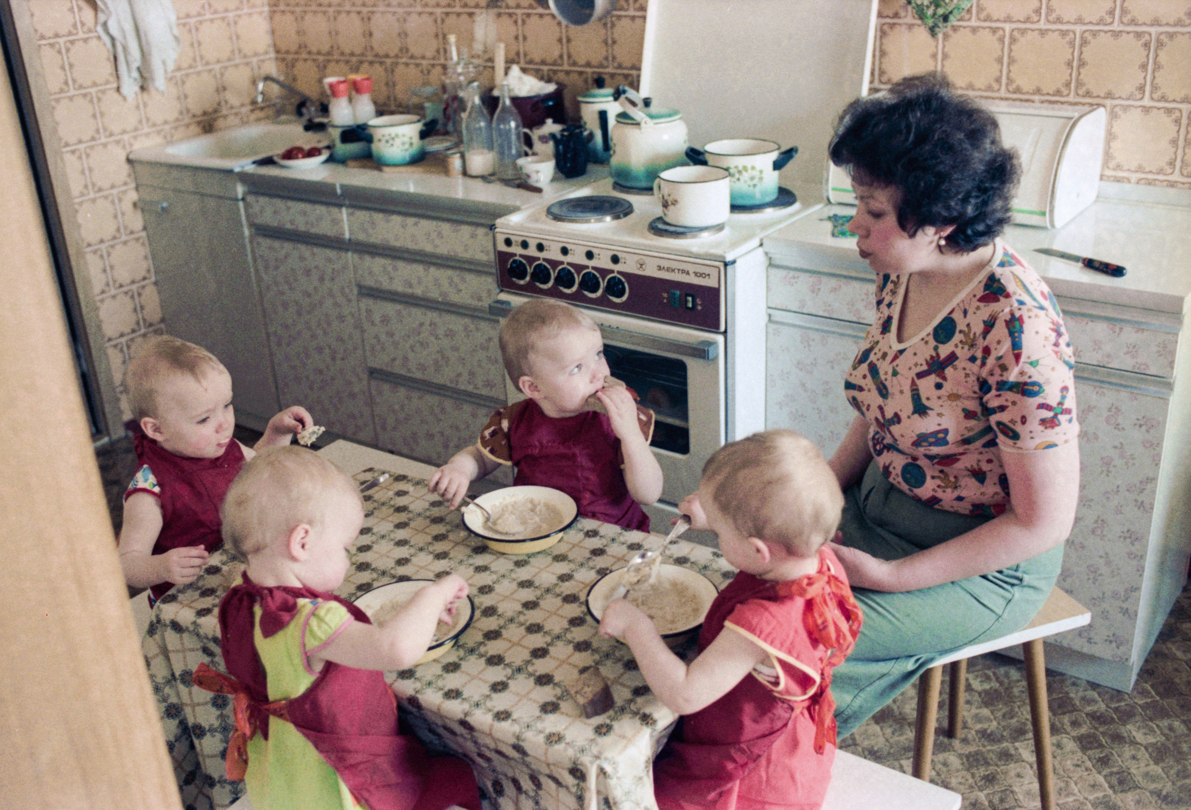 The twins eat porridge for breakfast.  Photo © TASS / Alexander Chumichev