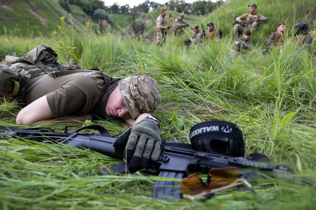 Солдат отдыхает в поле во время тактической стрельбы 28 июня 2022 года в Харьковской области, Украина. Полк "Азов". Фото © Getty Images / Paula Bronstein