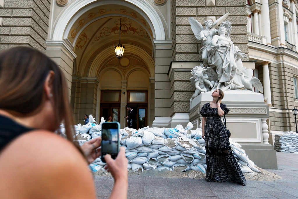 Девушка позирует для фото рядом с Одесским национальным академическим театром оперы и балета. Одесса, Украина, 17 июня 2022 года. Фото © Getty Images / STR / NurPhoto