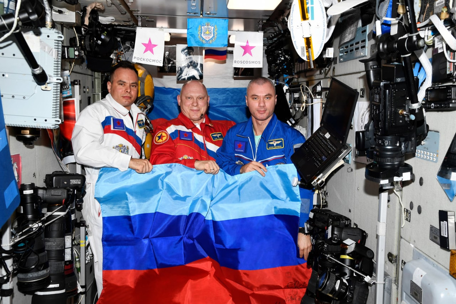 Российские космонавты с флагом ЛНР на МКС. Фото © Telegram / Госкорпорация "Роскосмос"
