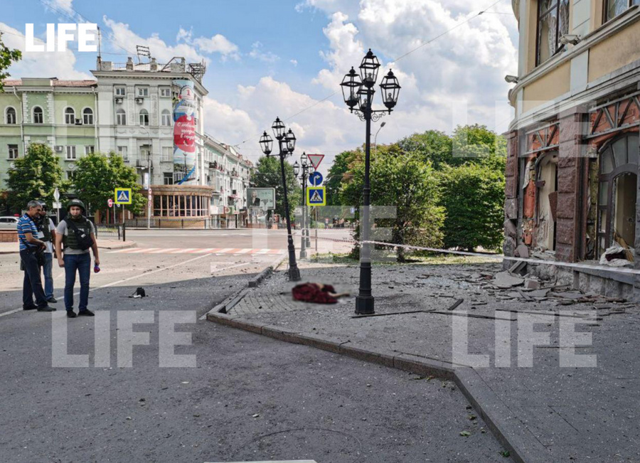 Тело одной из жертв обстрела драмтеатра (завёрнуто в красную штору) Фото © LIFE 