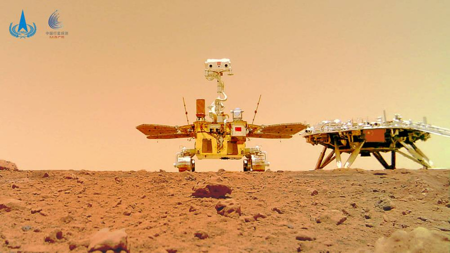 Марсоход "Чжужун" (слева) рядом с посадочным модулем. Снимок сделан с камеры, установленной отдельно от них на некотором расстоянии. Фото © ТАСС / Jin Liwang via www.imago-images.de