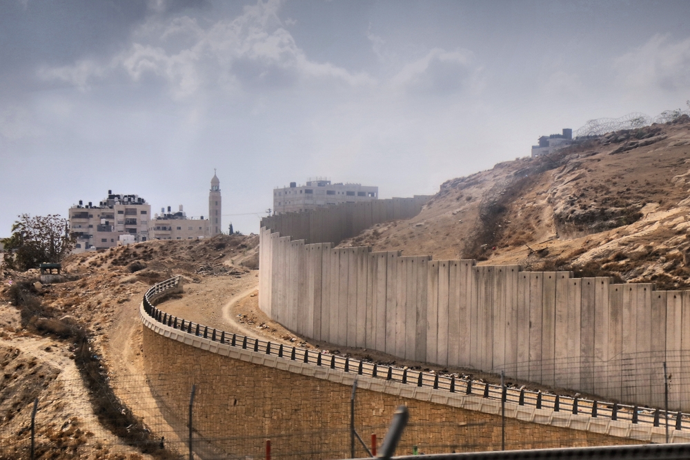 Бетонная стена "Зелёной линии", разделяющая Израиль и Палестину. Стена безопасности, также известная как барьер Западного берега. Окрестности Иерусалима. Фото © Shutterstock