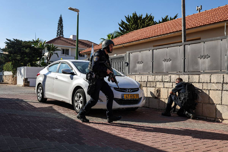 Израиль, Ашкелон: израильские полицейские укрываются за стеной во время ракетного обстрела из сектора Газа. Фото © Getty Images / dpa / Ilia Yefimovich