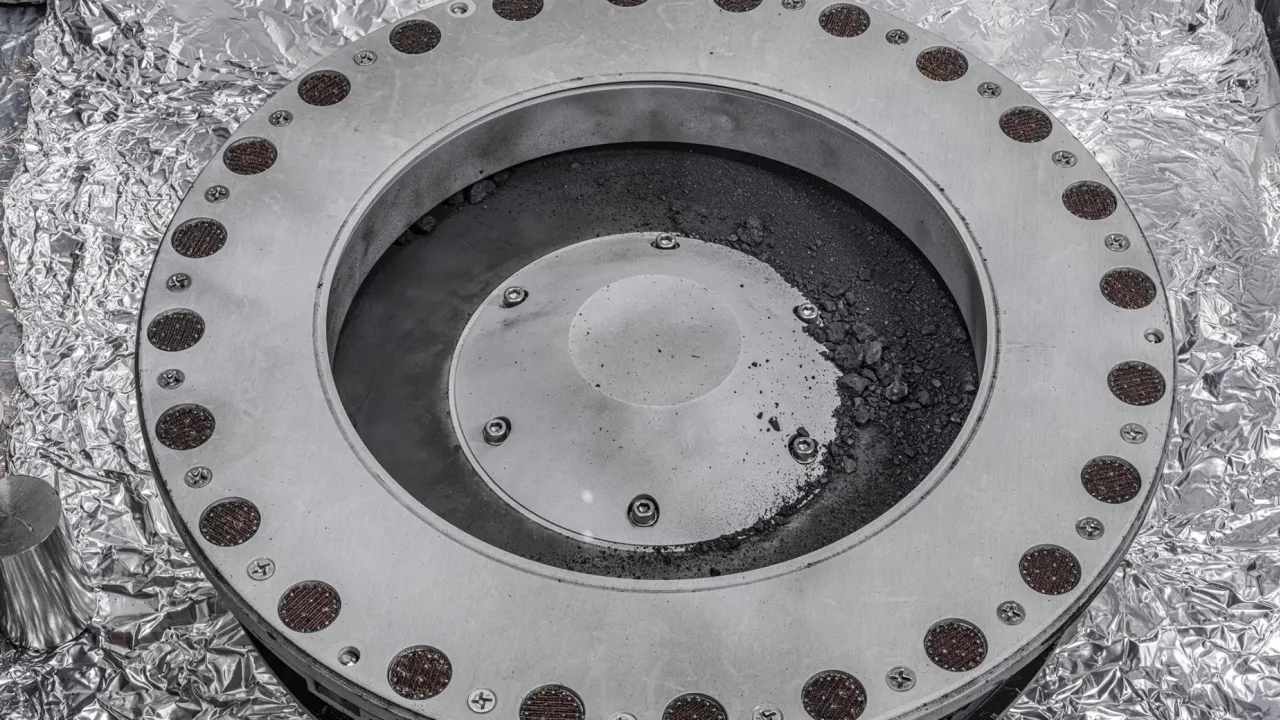 Частицы астероидного грунта на крышке грунтозаборного устройства зонда OSIRIS-REx. Фото © NASA / Erika Blumenfeld & Joseph Aebers