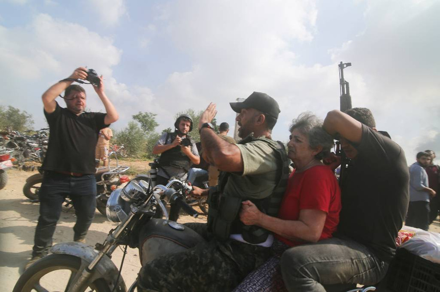Палестинские боевики захватывают в плен мирных израильтян. Обложка © AP / TASS / Hatem Ali