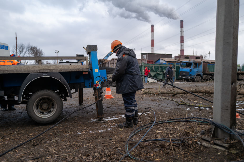 Сотрудники электрокомпании работают в промышленной зоне в Киеве, чтобы восстановить электроснабжение после утреннего ракетного удара. Фото © Getty Images / Spencer Platt