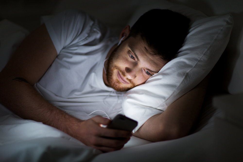 Голубой свет от экрана смартфона блокирует выработку гормона сна, а недосып — привычка, которая внешне сильно старит. Фото © shutterstock