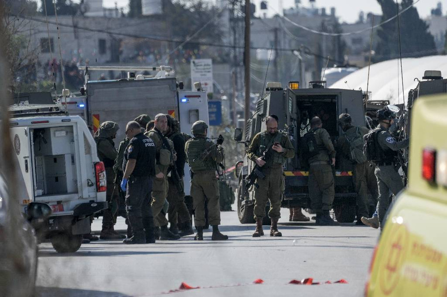 Израильские силы безопасности осматривают место стрельбы в городе Халхул. Фото © ТАСС / AP / Mahmoud Illean