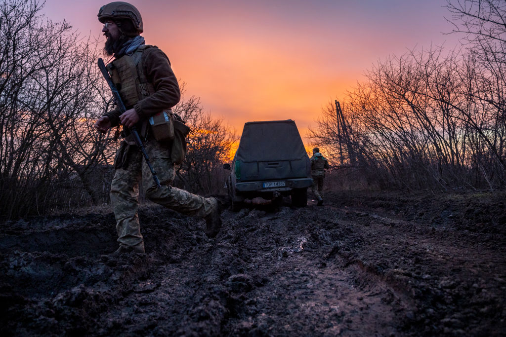 Солдат украинской штурмовой бригады идёт по грязной дороге, используемой для транспортировки и размещения 105-мм гаубиц L118 британского производства, 4 марта 2023 года недалеко от Бахмута, Украина. Фото © Getty Images / John Moore