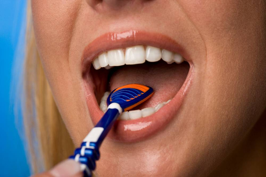 Для очистки языка можно использовать как двустороннюю зубную щётку, так и специальный скребок. Фото © Getty Images / Westend61